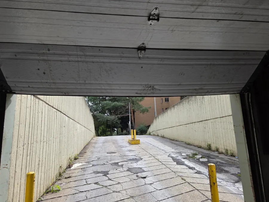 Broken garage entrance door and damaged ramp