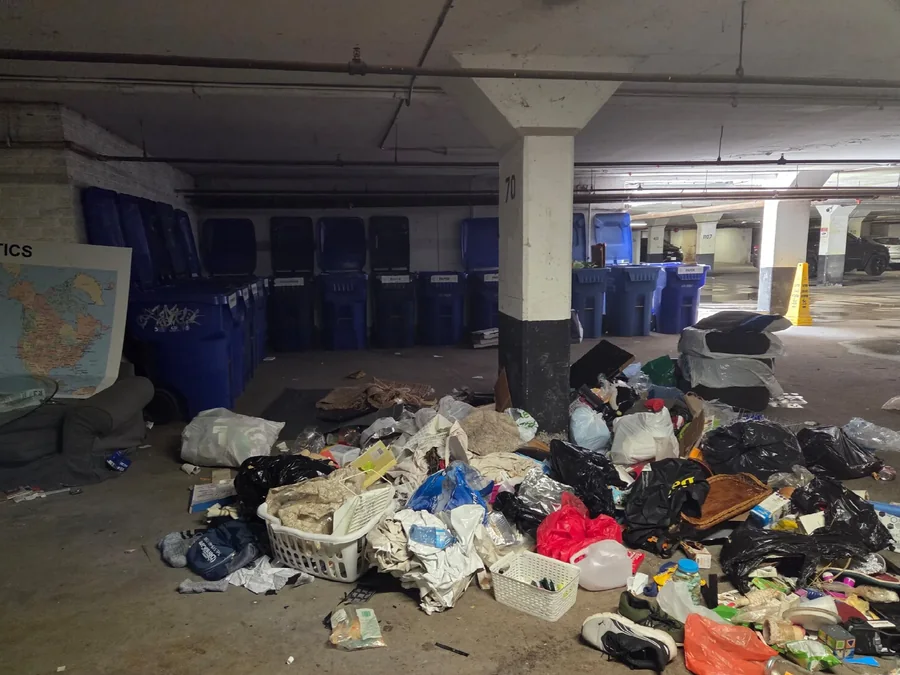 Garbage and clothing piled in an underground parking garage
